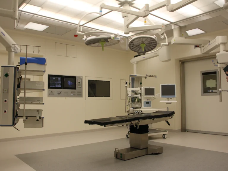 An operating room with a surgical table, overhead lights, and medical equipment