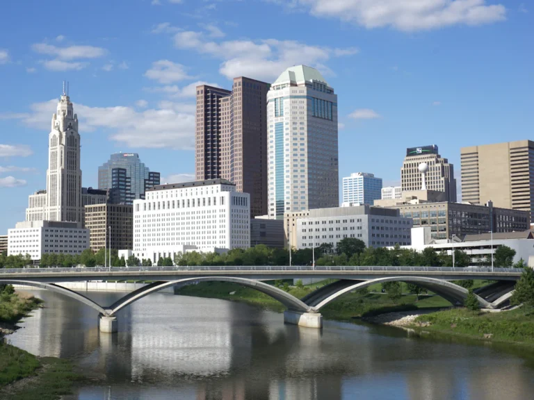 A bridge over a river with a city in the background