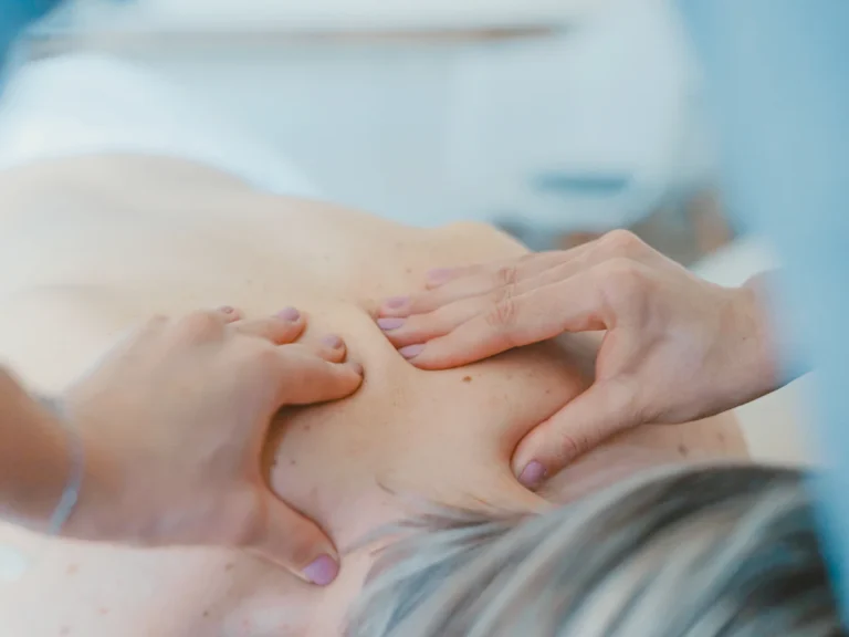Person massaging the back of a woman