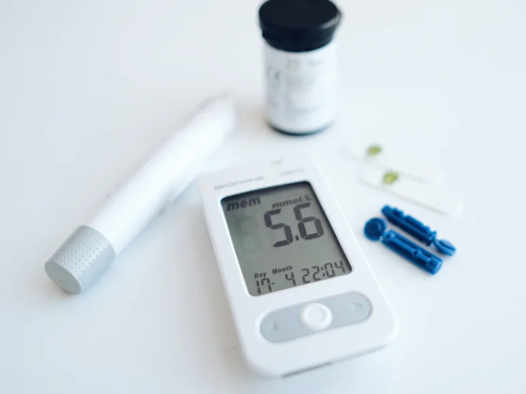 A blood glucose meter with a lancing device and test strips on white