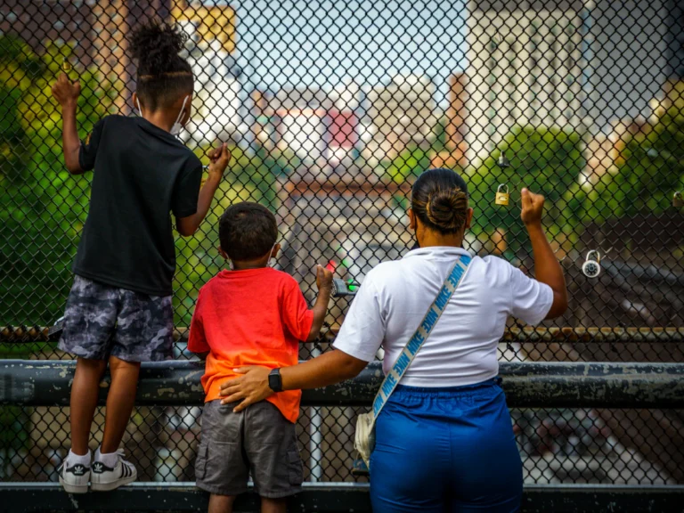 A group of people standing next to each other near a fence