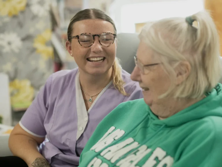 Two women laughing together indoors