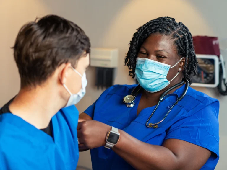 A woman in a blue scrub suit and a man in a blue scrub suit