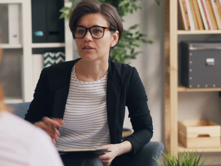 A woman sitting on a couch talking to another woman