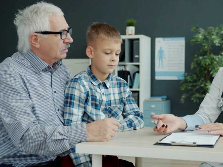 Doctor consults with grandfather and grandson in office