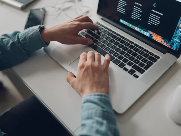 Person wearing long-sleeve top working on laptop