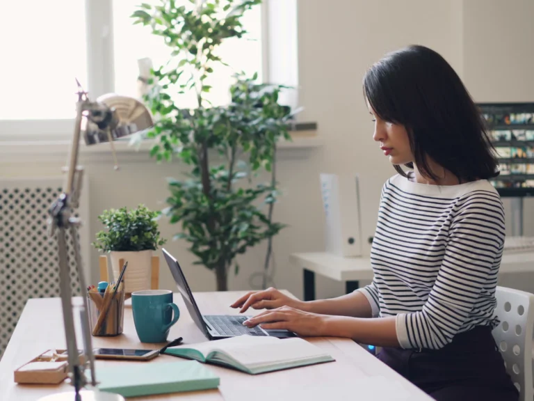 A woman sitting at a desk using a laptop computer