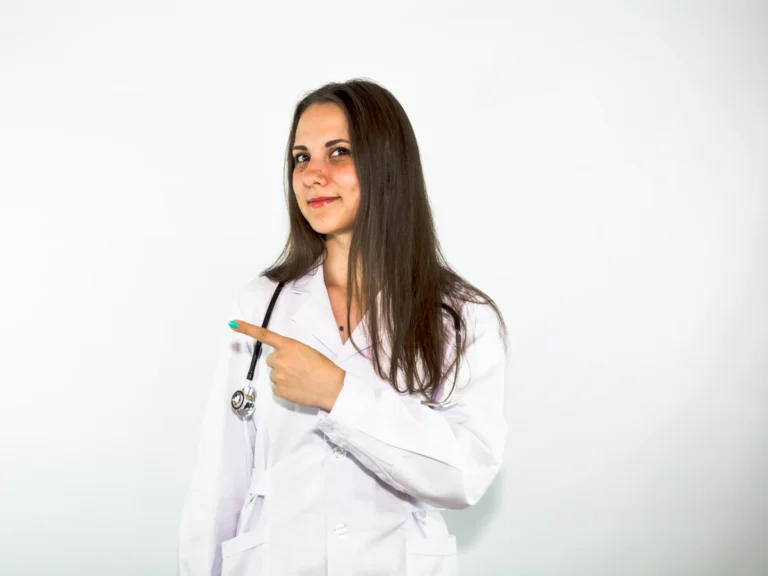 A woman in a white lab coat pointing at something