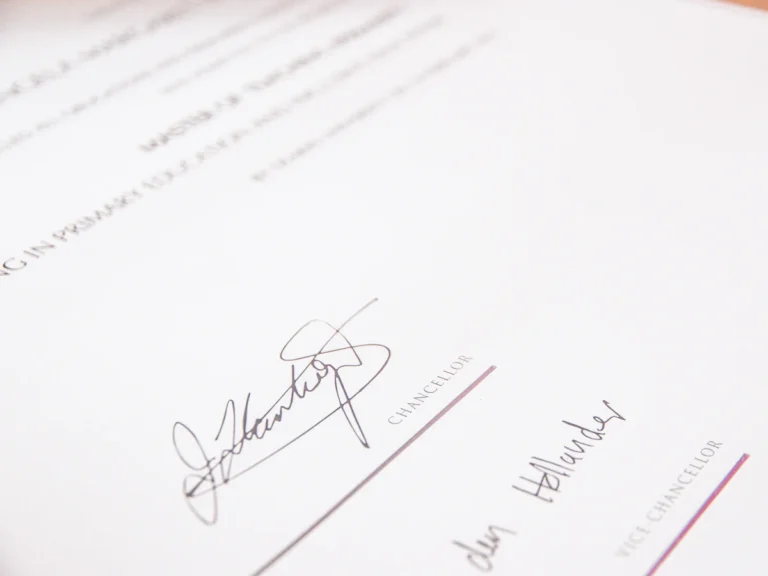A university degree certificate with a red seal and two signatures