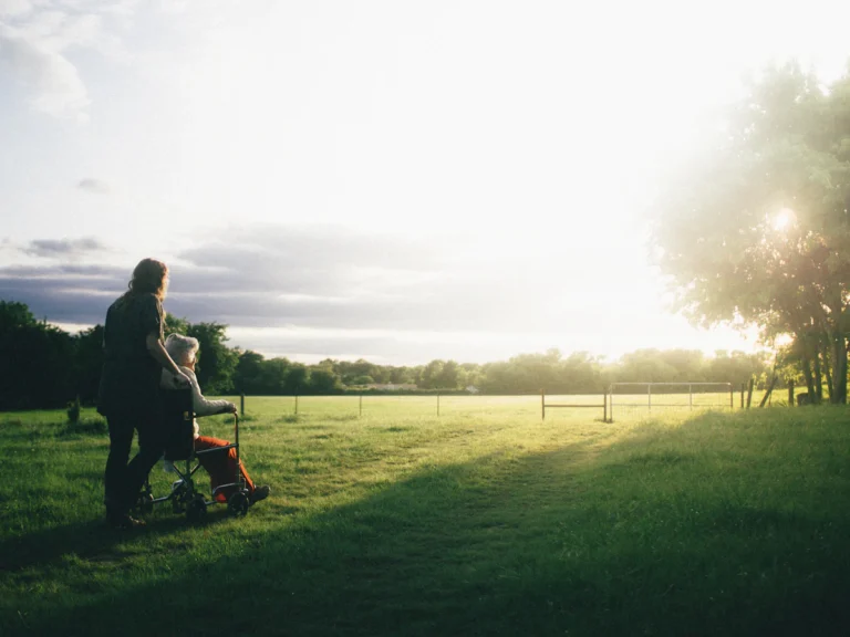 Woman standing next to woman riding wheelchair