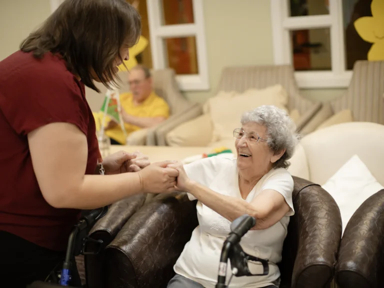 Caregiver assists elderly woman with walker