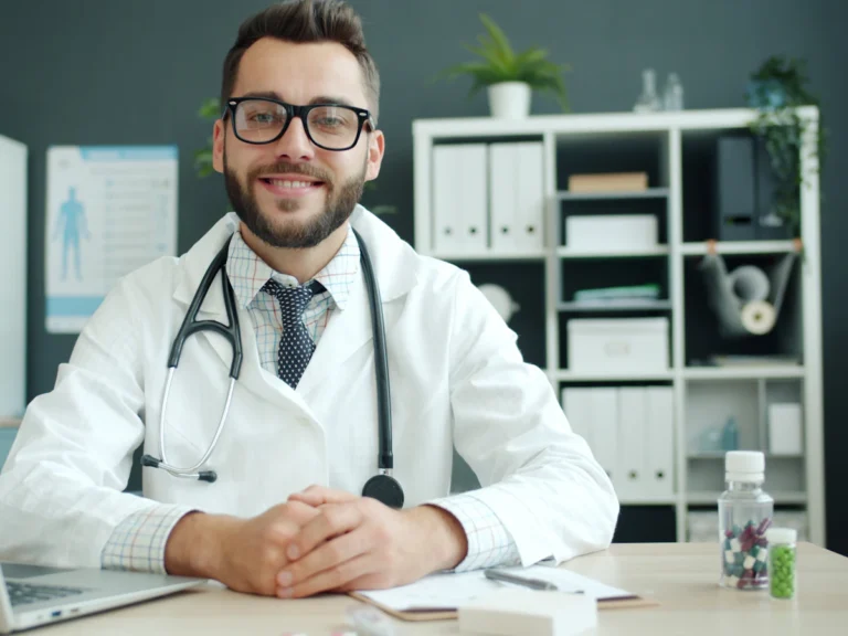 Doctor wearing a stethoscope sits at a desk