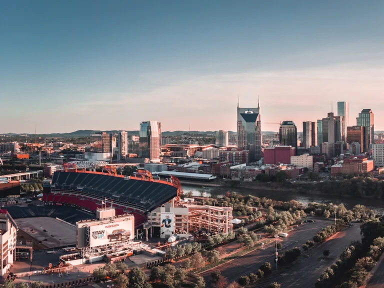 American football arena beside building and roadway during daytime