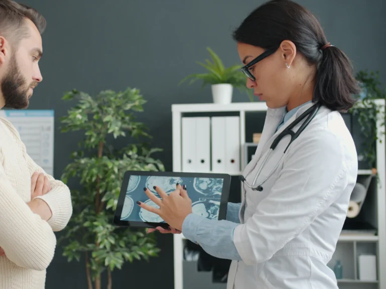 Doctor shows patient medical scan on tablet