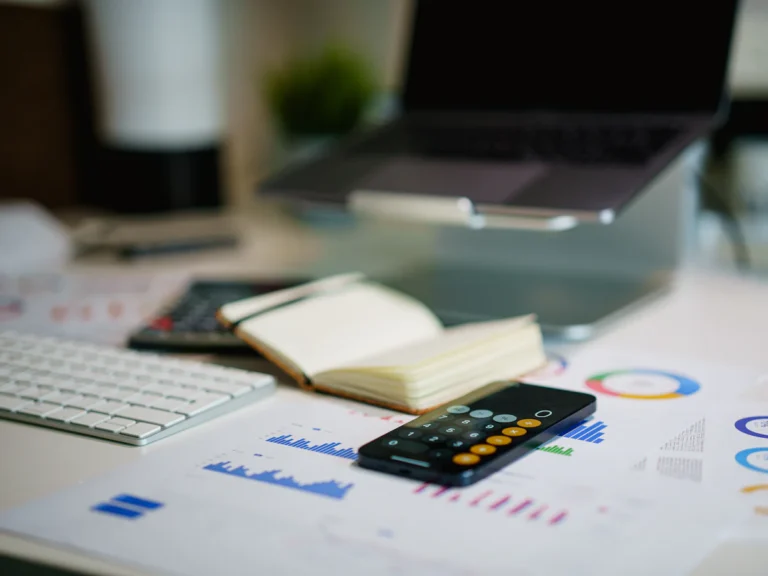 Office desk with smartphone and financial charts